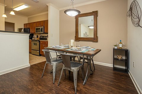 A dining room with a table and chairs.
