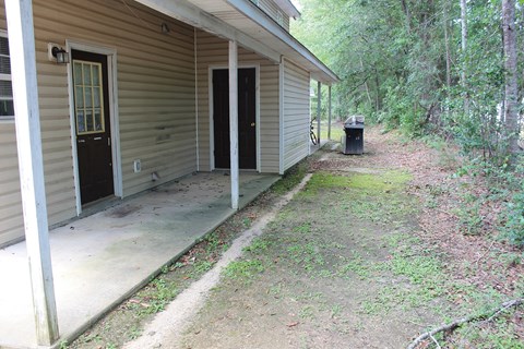 A tan house with a black door and a window.