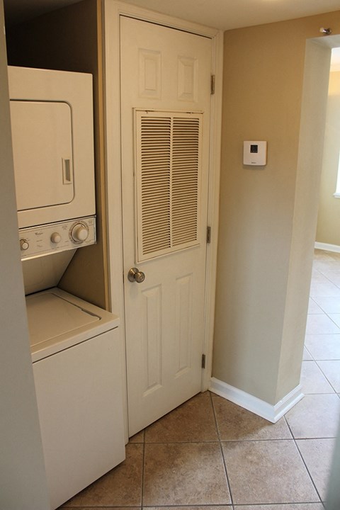 a laundry room with a washer and dryer and a white door