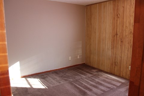 an empty room with carpet and a wooden door