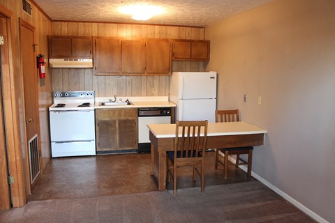 a kitchen and dining area with a table and chairs and a refrigerator