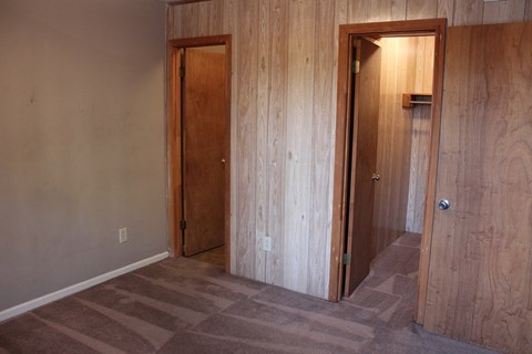 an empty room with two doors and a carpeted floor