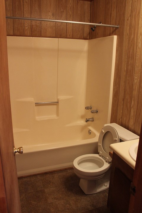 a bathroom with a toilet and a tub and a sink