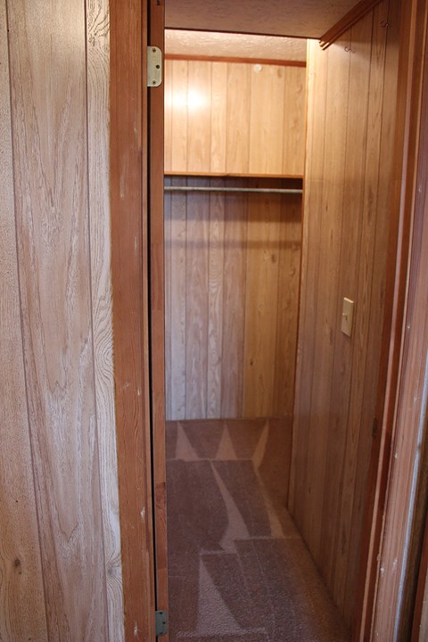 an empty closet in a wood walled room