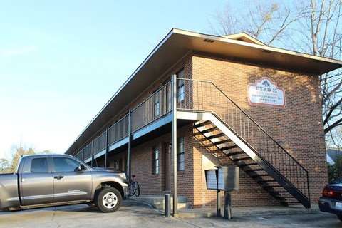 a truck parked in front of a brick building with stairs