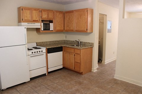 a kitchen with white appliances and wooden cabinets