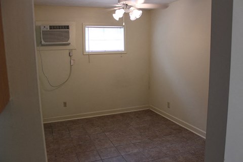 an empty room with a ceiling fan and a window