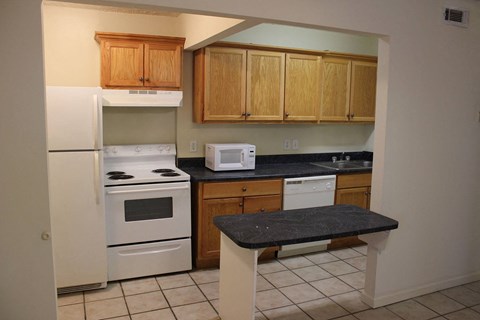 a kitchen with white appliances and wooden cabinets