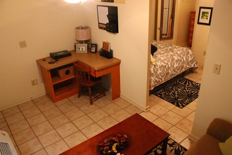 A room with a desk and a bed.