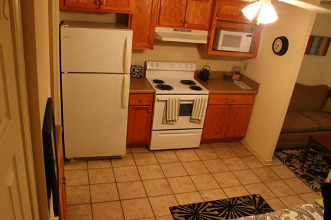 A small kitchen with a white refrigerator and a white stove top oven.