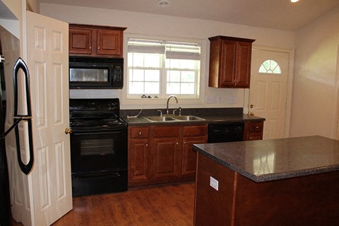 a kitchen with black appliances and wooden cabinets