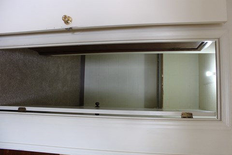 a mirror hanging on a wall above a window