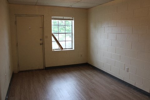an empty room with wooden floors and a window