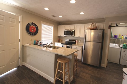 A kitchen with a white counter and a stainless steel refrigerator.