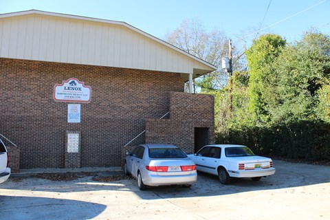Two cars are parked in front of a building with a sign that says Lenox.