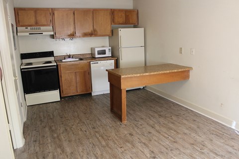 A kitchen with a white fridge, black oven, and a microwave.
