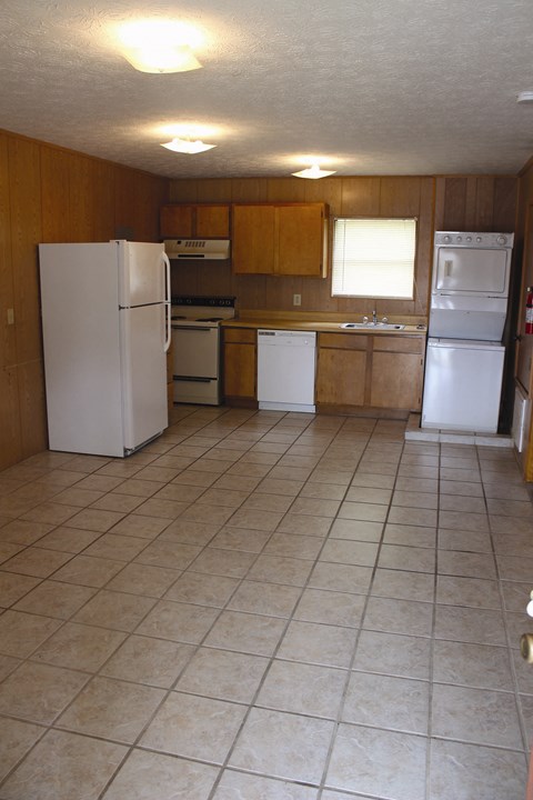 A kitchen with white appliances and wooden cabinets.