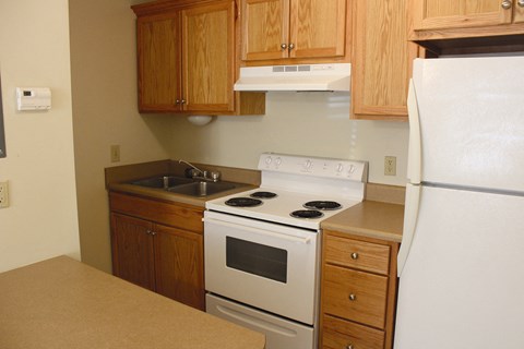 a kitchen with white appliances and wooden cabinets