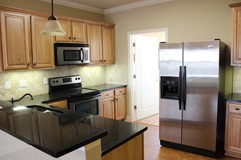 A kitchen with a black counter top and stove.