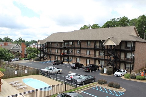 a view of an apartment building with cars parked in a parking lot