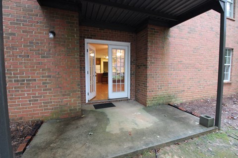 A brick house with a white door and a black roof.