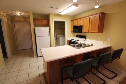 A kitchen with a white fridge and a white counter top.