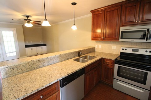 A kitchen with granite countertops and stainless steel appliances.