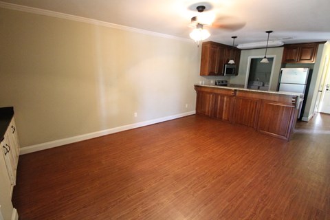 A kitchen with wooden floors and a ceiling fan.