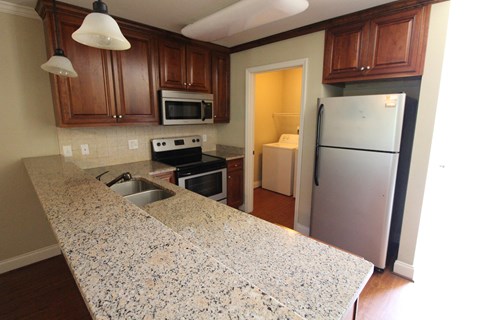 a kitchen with granite counter tops and a stainless steel refrigerator