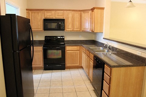a kitchen with black appliances and wooden cabinets