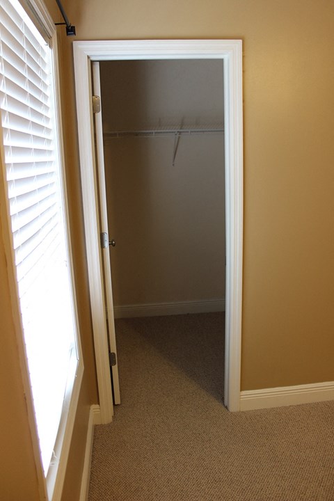 A white door is open to a room with a carpeted floor.