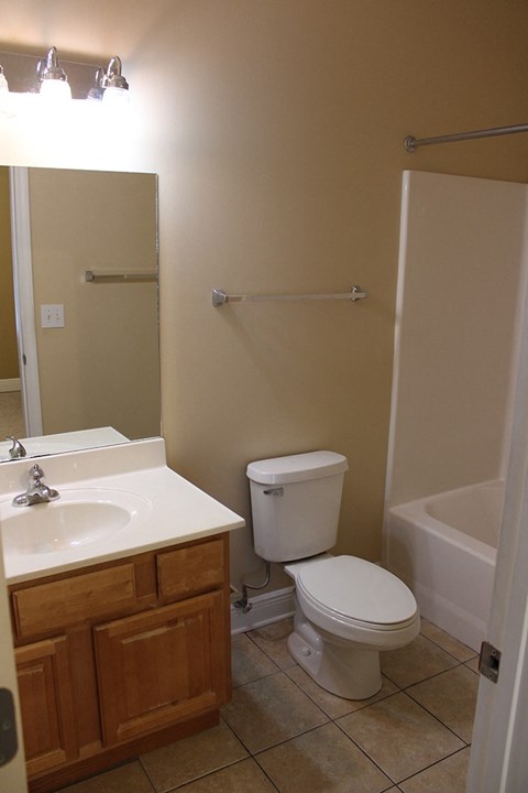 A white toilet sits next to a white sink in a bathroom.
