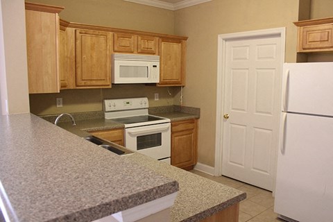 a kitchen with granite counter tops and wooden cabinets