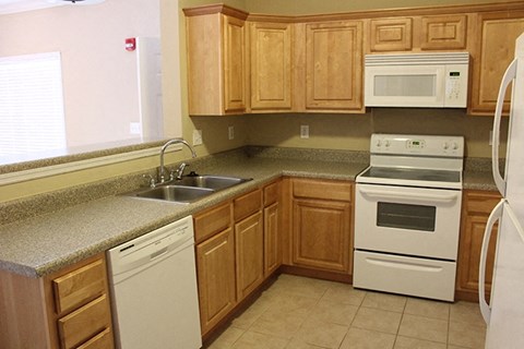A kitchen with wooden cabinets and white appliances.