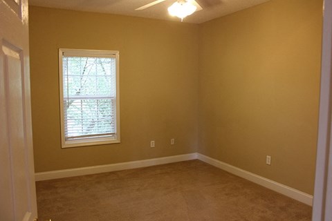 a empty room with a window and a carpet