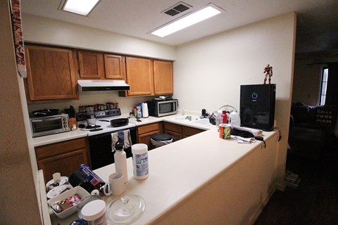 A kitchen with a microwave, oven, and a refrigerator.