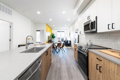 A modern kitchen with wooden cabinets and a black stove top oven.
