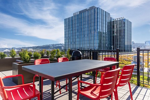 a table and chairs on a balcony with a city in the background