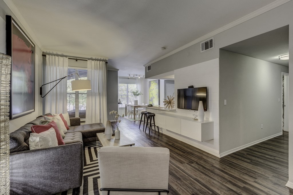 a living room with a couch and a chair and a kitchen
