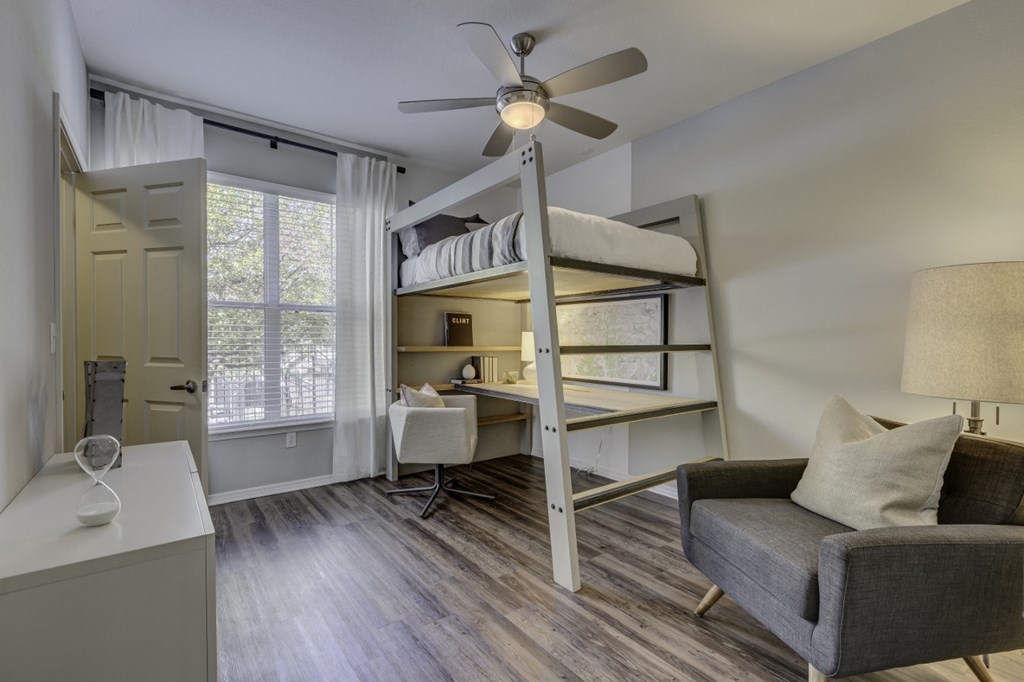 a living room with a bunk bed and a ceiling fan