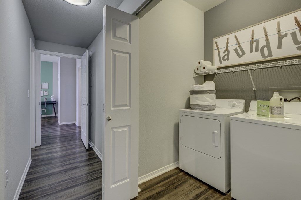 a laundry room with a washer and dryer and a hallway to a bathroom