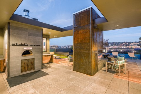 A modern outdoor kitchen with a pizza oven and a tall column.