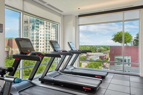 A gym with treadmills and a view of the city.