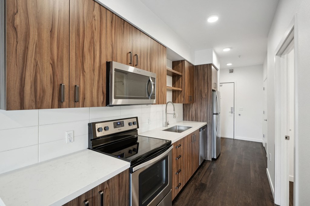a kitchen with wooden cabinets and a stove and microwave