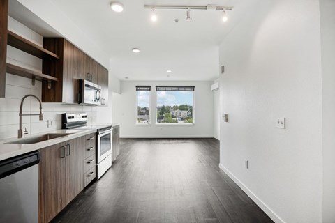 an empty kitchen with wooden floors and white walls