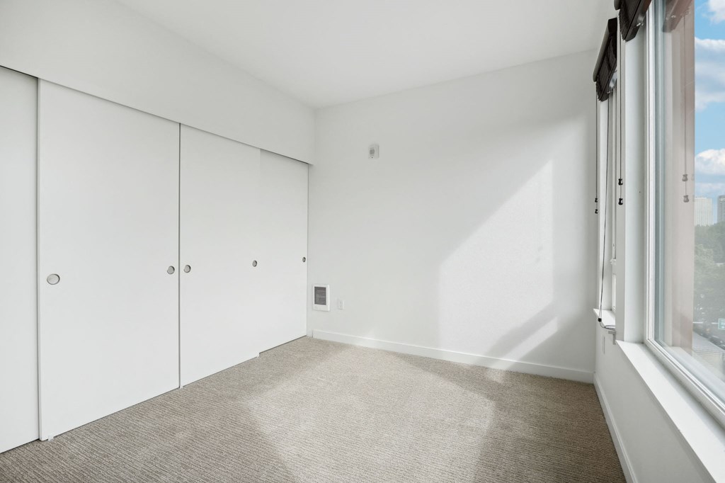 an empty room with white walls and a window