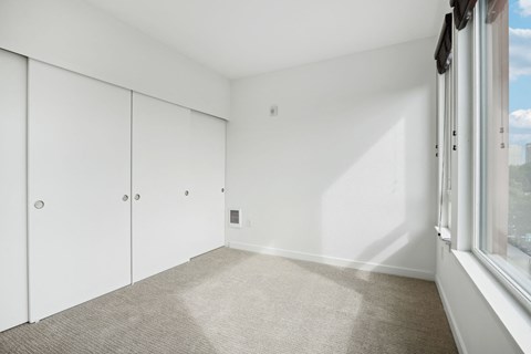 an empty room with white walls and a window