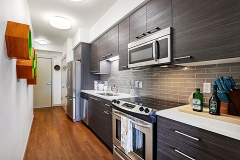 A modern kitchen with a stainless steel oven and microwave.