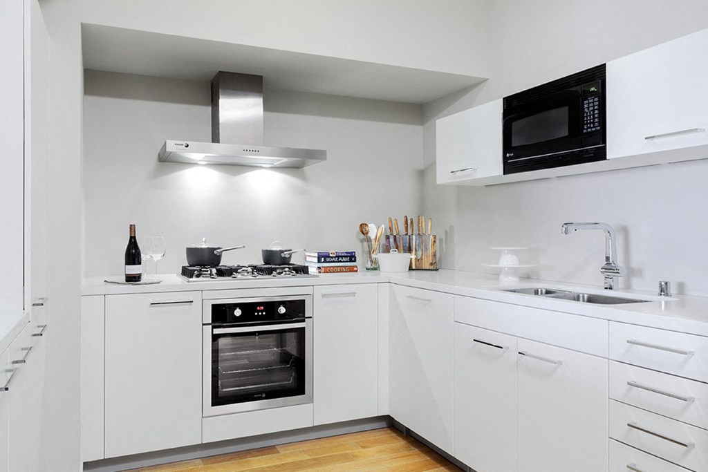 a kitchen with white cabinets and a stainless steel stove