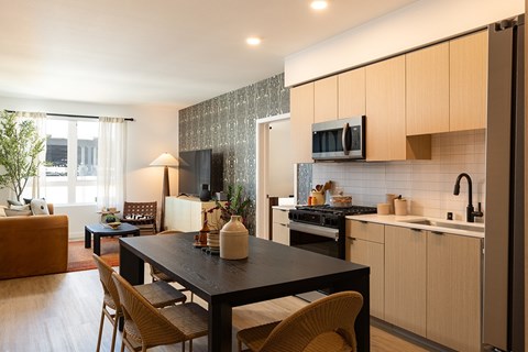 A modern kitchen with a dining table and chairs.